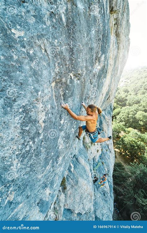 Strong Muscular Man Rock Climber With Naked Torso Dynamically Climbing