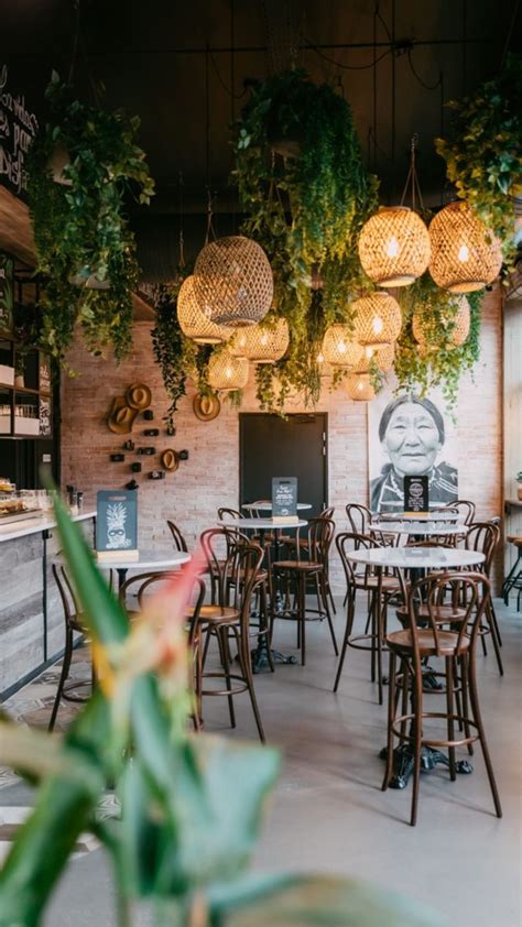 The Interior Of A Restaurant With Plants Hanging From The Ceiling And