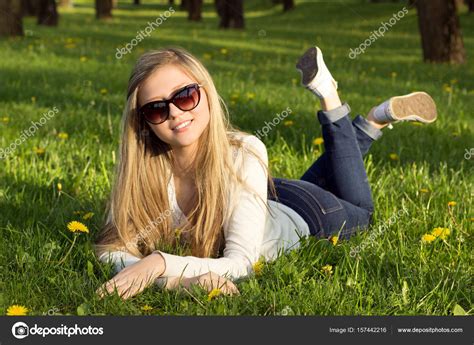 Girl in park lying on the grass. Stock Photo by ©AlinaSolo 157442216