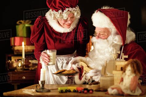 Mrs Claus Bringing Homemade Cookies To Santa Claus Stock Photo