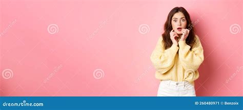 Portrait Of Scared And Shocked Brunette Girl Gasping And Holding Hands