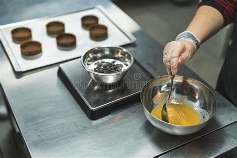 Chef Pouring Caramel In A Bowl Circle Shapes On A Tray In The