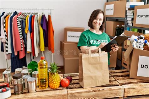 Brunette Woman With Down Syndrome Checking Donated Food At Donations