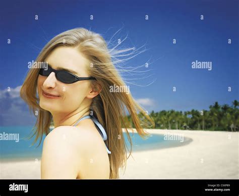 Smiling Young Woman With Sunglasses And Bikini On The Beach In The