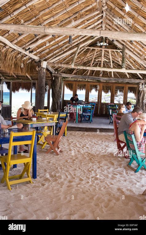 Tourists In Colorful Thatched Roof Restaurant On Tulum Beach With View