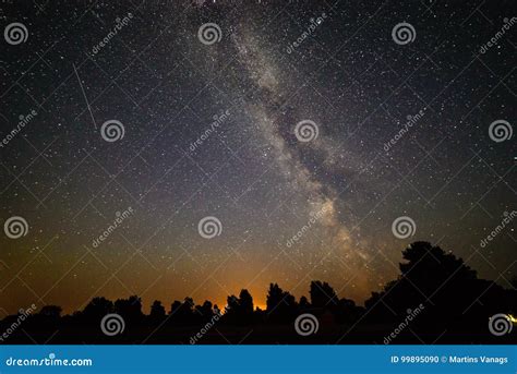 Colorful Milky Way Galaxy Seen In Night Sky Over Trees Stock Photo