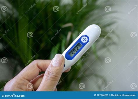 Hand Holding A Thermometer With A High Fever Temperature Of More Than