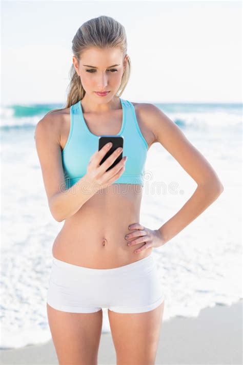 Blonde Delgado Enfocado En Mandar Un SMS De La Ropa De Deportes Foto De