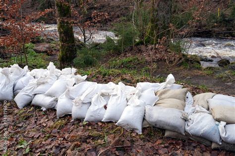 Sandsäcke an einem Bach zum Schutz vor Hochwasser Flut Überschwemmung