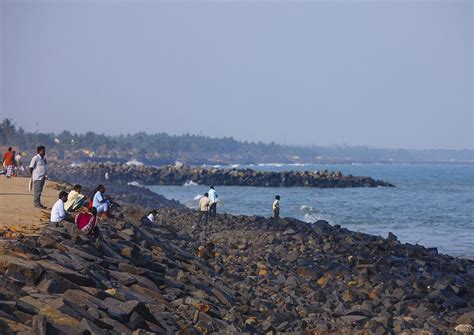 People Sitting On Rocks Of A Seawall At Pondicherry Seafront Looking