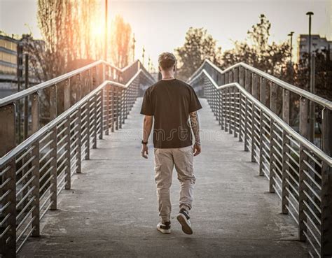 Man Walking Across A Bridge Over Water Stock Image Image Of