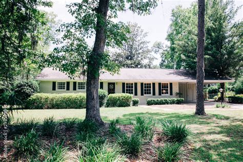 Front view of exterior white cream brick 1950's house with black ...