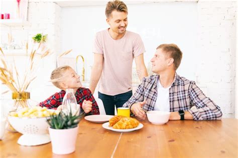 Felices Padres E Hijos Jóvenes Desayunan En La Cocina La Familia Gay Con Un Hijo Tiempo Juntos