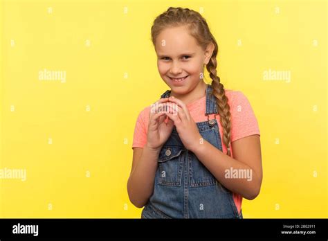 Portrait Of Sneaky Scheming Little Girl In Denim Overalls Thinking Over