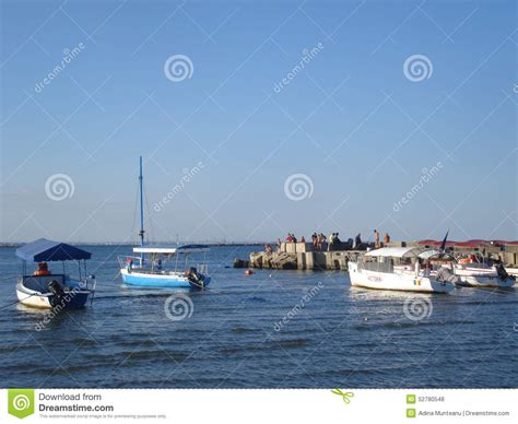 Gente Que Goza Del Sol En El Embarcadero Y Barcos Del Ocio Que Esperan