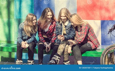 Cute Girls Sitting On The Bench In The Park And Laughing Stock Image