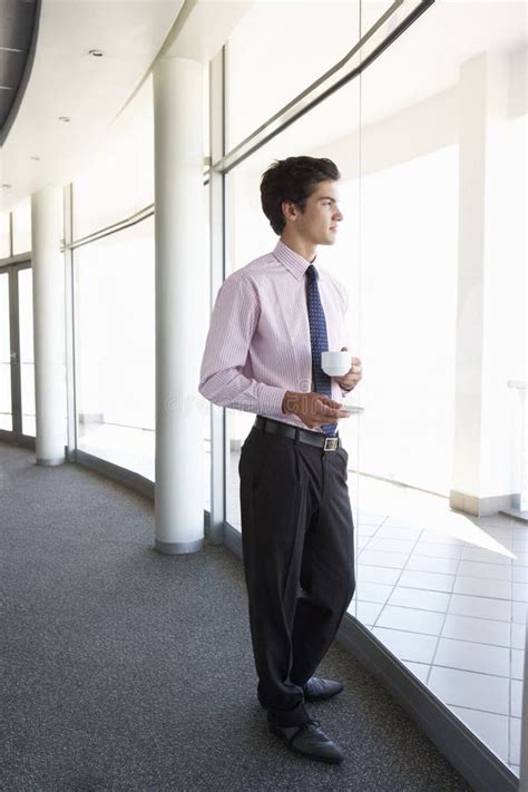 Hombre De Negocios Joven Standing in Corridor Del Café De Consumición