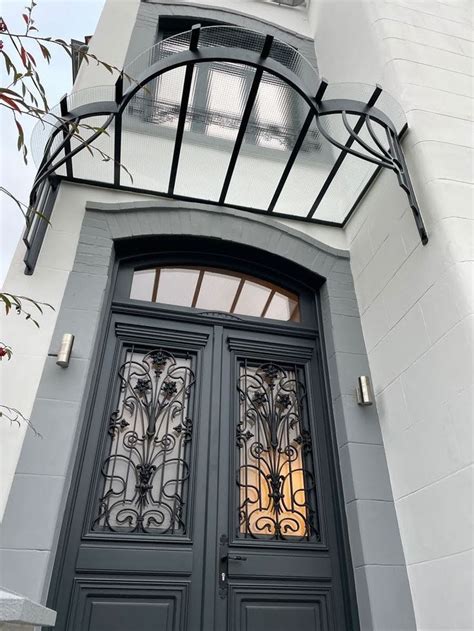 The Front Door To A House With Wrought Iron Work On It S Sides And Windows