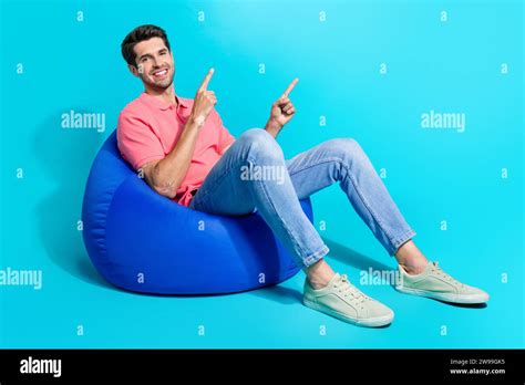 Full Length Photo Of Smiling Happy Man Sitting Bean Bag Point Fingers