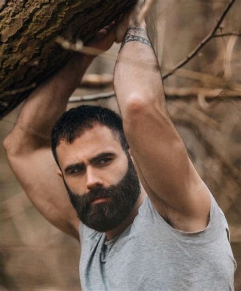 A Man With A Beard Holding Onto A Tree Branch