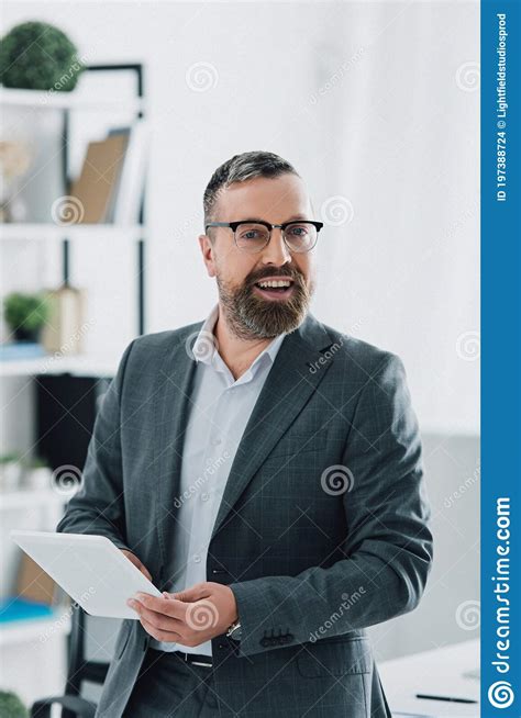 Businessman In Formal Wear And Glasses Using Digital Tablet In Office