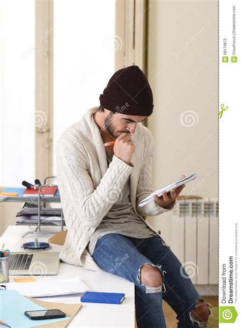 Trendy Businessman In Cool Hipster Beanie And Informal Look Writing On