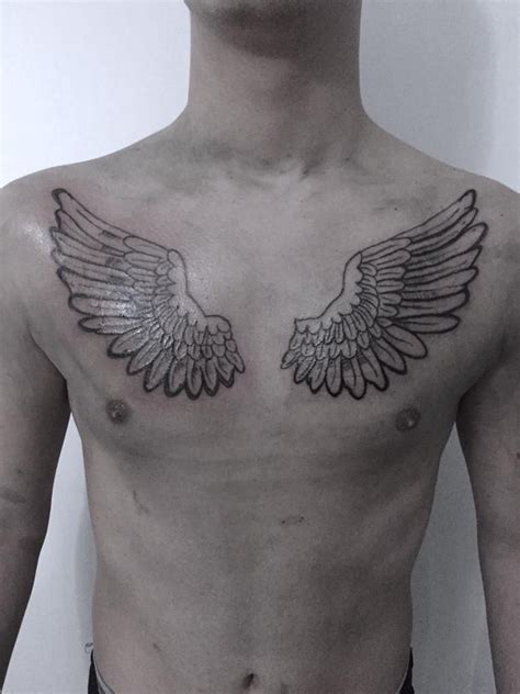 A Man With An Angel Wing Tattoo On His Chest