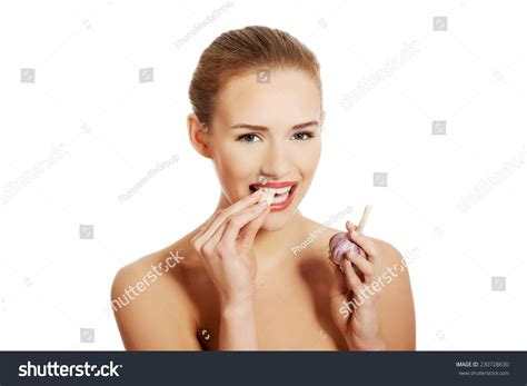 Стоковая фотография 230728630 Portrait Nude Woman Eating Garlic