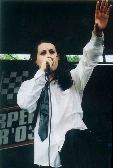 A Man In White Shirt And Black Tie Holding Up His Hand To The Air While