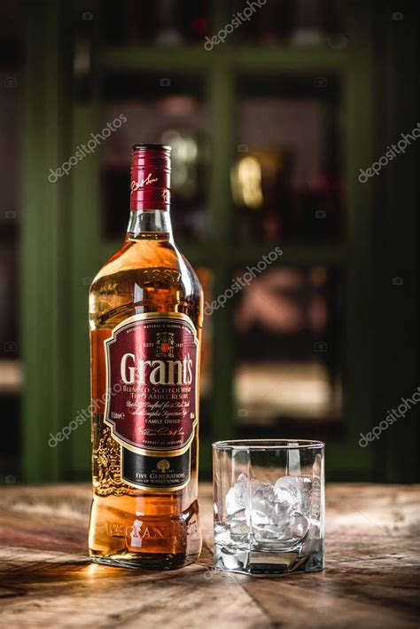 Botella De Whisky Grant Y Vaso Con Cubitos De Hielo Sobre Mesa De