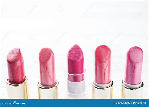 Set Of Colored Pink Lipsticks On White Background Women`s Cosmetics