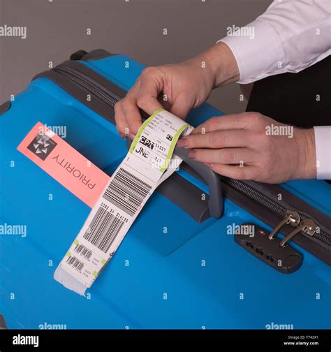 Airline Check In Luggage Tag Being Attached To A Suitcase Priority