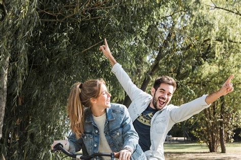 Pareja Montando Bicicleta En El Parque Foto Premium