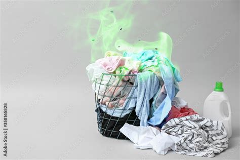 Laundry basket with dirty clothes on grey background Stock Photo ...