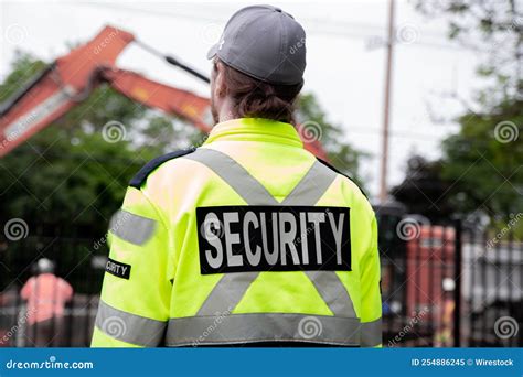 Security Guard Patrolling The Street Next To The Construction Area