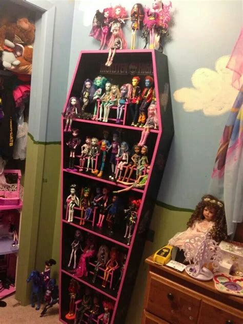 A Pink Shelf Filled With Lots Of Barbie Dolls And Other Toy Items In A Room