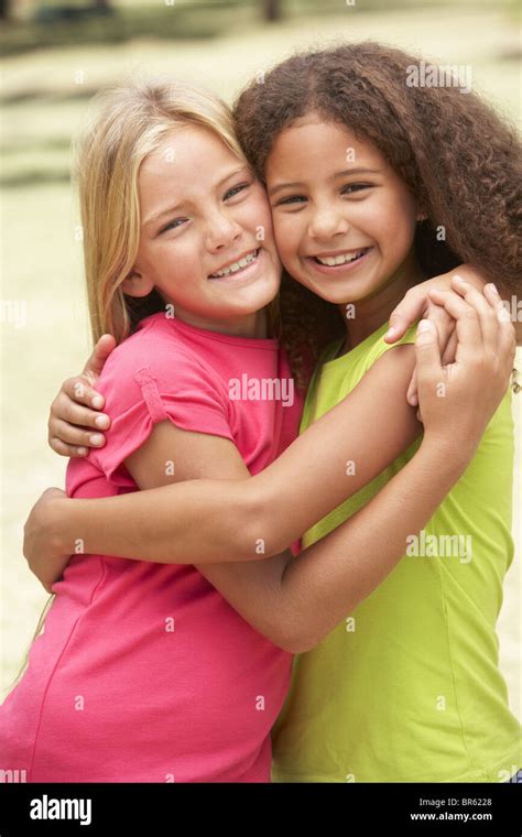Two Girls In Park Giving Each Other Hug Stock Photo Alamy