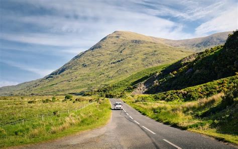 Un Coche Circula Por Una Carretera Con Una Monta A Al Fondo Foto Premium