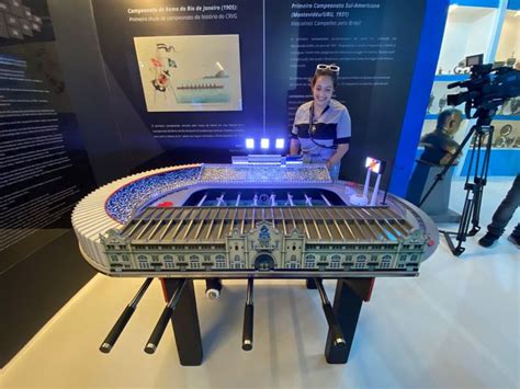 A Man Standing Next To A Model Train On Display In Front Of A Cameraman