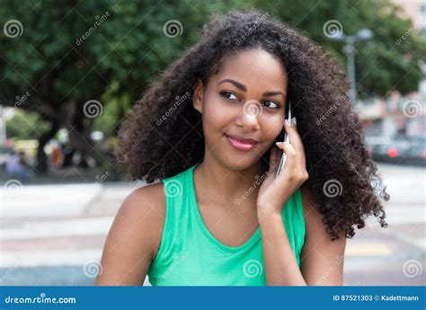 Mujer Latina Sonriente Con El Pelo Rizado Y La Camisa Verde En El