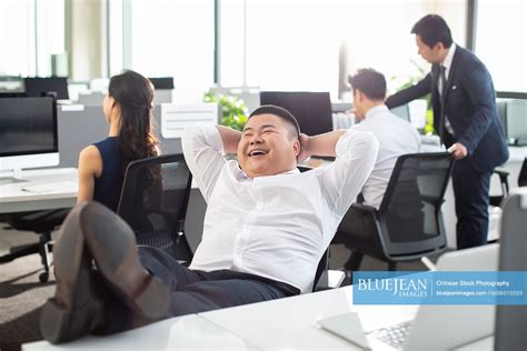 Chinese Businessman Slacking Off In Office High Res Stock Photo For