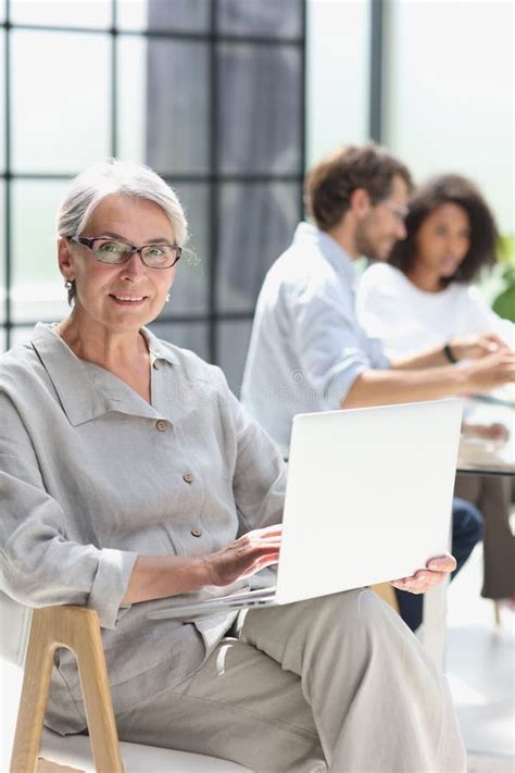 Mature Woman Sitting With Laptop Looking At Camera Stock Image Image Of Occupation Office