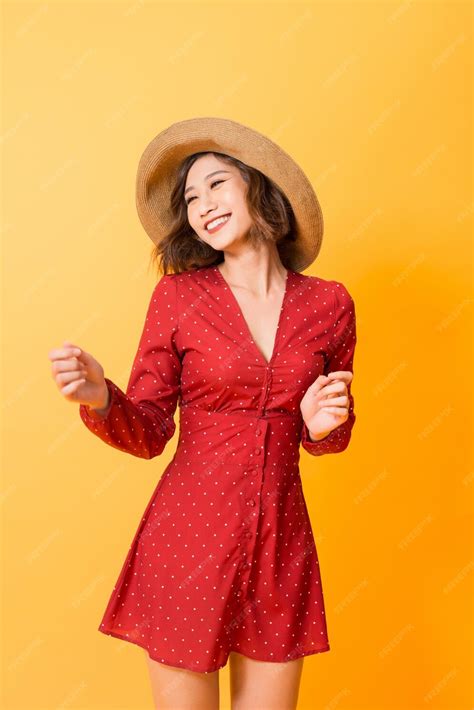 Premium Photo Asian Girl Wearing Red Dress With Straw Hat Over Orange