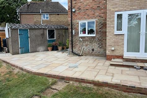 Raised Indian Sandstone Slabbed Patio With Brick Retaining Wall In