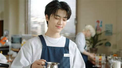 A Man In An Apron Is Pouring Something Into A Cup