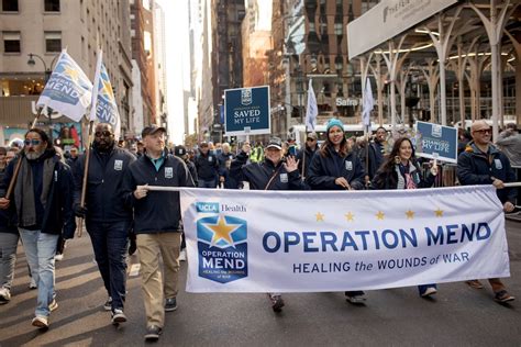 Photo | A group of people marching in New York’s Veterans Day parade behind a bannder reading ...