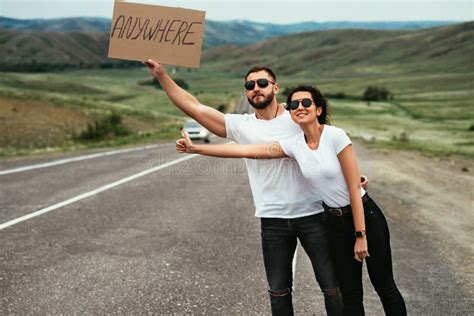 Um Homem E Uma Mulher Estão a Viajar De Carona Um Jovem Casal Vai