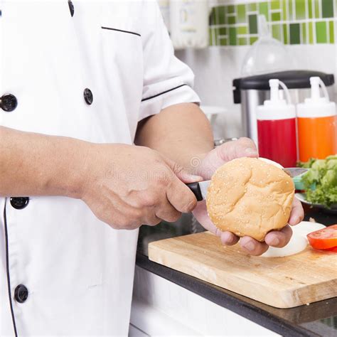 Petit Pain D Hamburger De Lambeau De Chef Avec Le Couteau Photo Stock