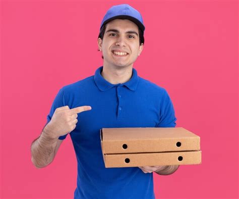 Repartidor Joven Sonriente En Uniforme Azul Y Gorra Sosteniendo