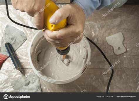 Mixing Plaster Solution In A Bucket Using Electric Drill Stock Photo By